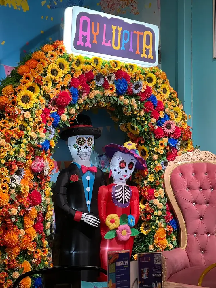 Arco de flores con catrinas en el local