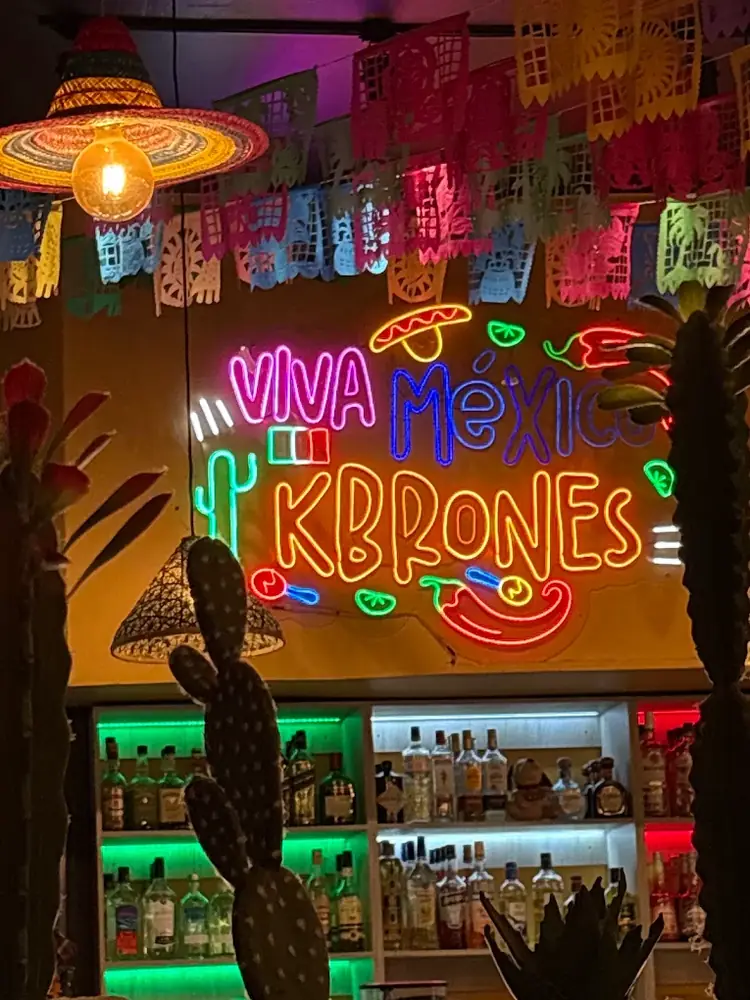 La barra, con luces de neón y botellas